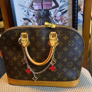 Louis Vuitton Monogram Alma Satchel in Brown with Red Charm Accents
